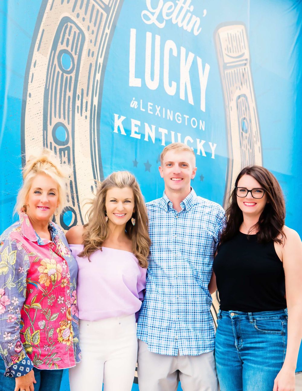Four members of the Legit team in front of a Lexington, Kentucky mural